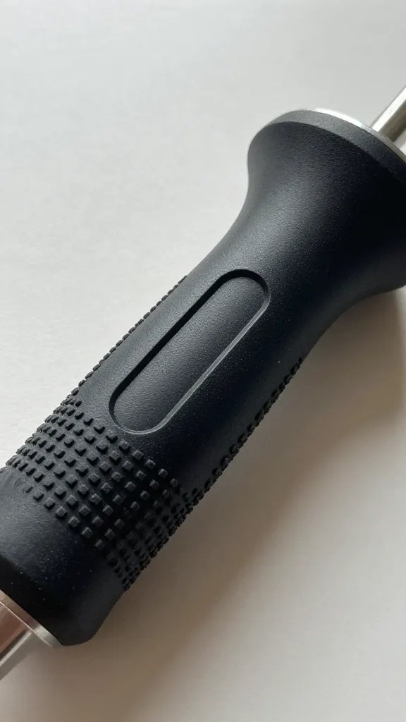 closeup of adaptive grip handle on craft tool with textured surface, neutral desk